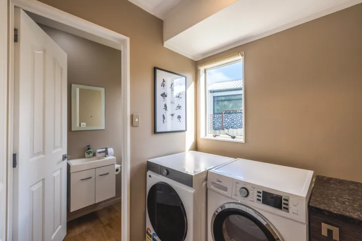 Bay Song Onetangi laundry area and downstairs bathroom with shower