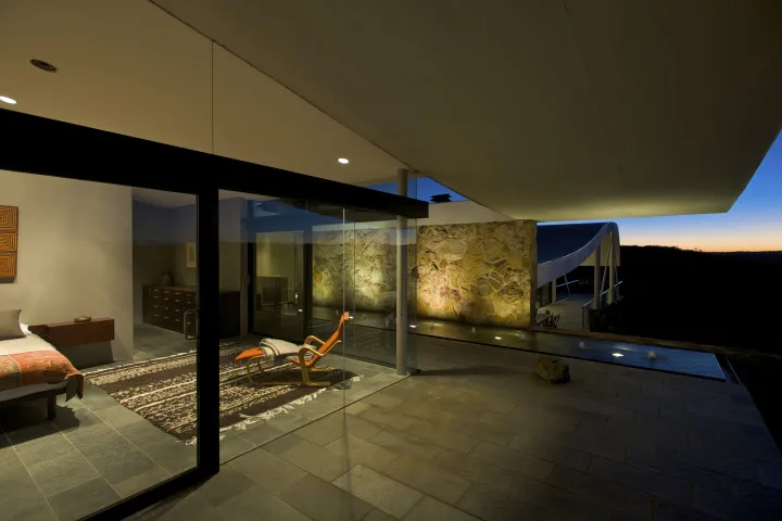 Bedroom with glass front and expansive views of Australian bush at the iconic Seidler House, private contemporary luxury holiday accommodation in Australia Southern Highlands