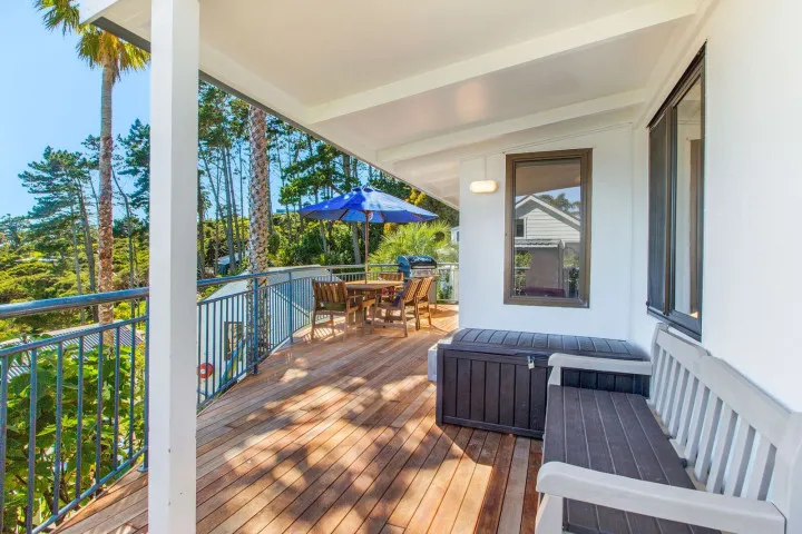 Sunny sheltered deck with outdoor seating, BBQ and sea view