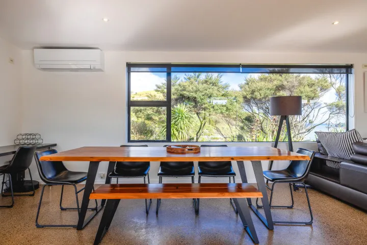 Wharetana Bay Villa Dining space with large heatpump and wood burner