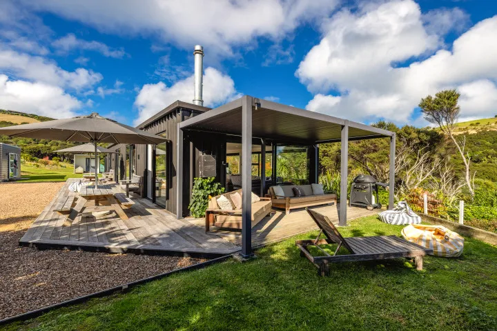 Wharetana Bay Villa Exterior lounging area of the house with louvred covered area